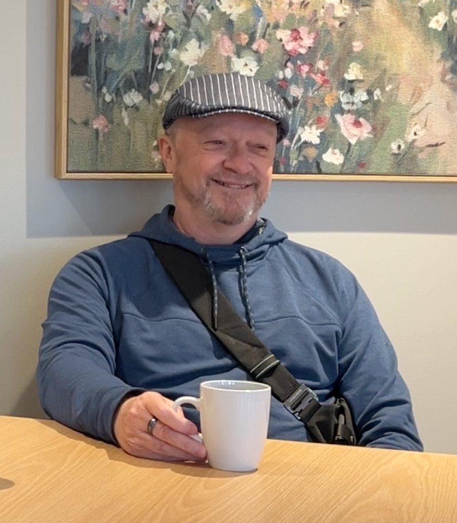 Jacques smiling with a coffee
