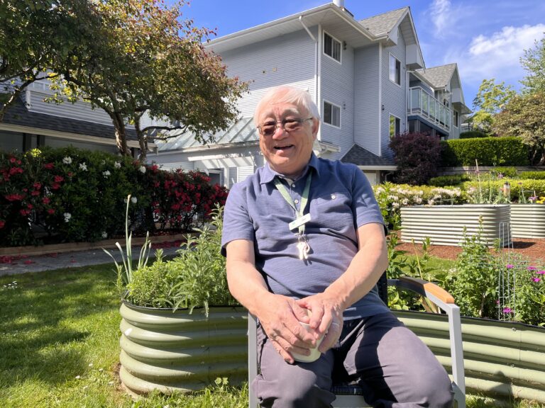 Joe smiling with coffee in garden