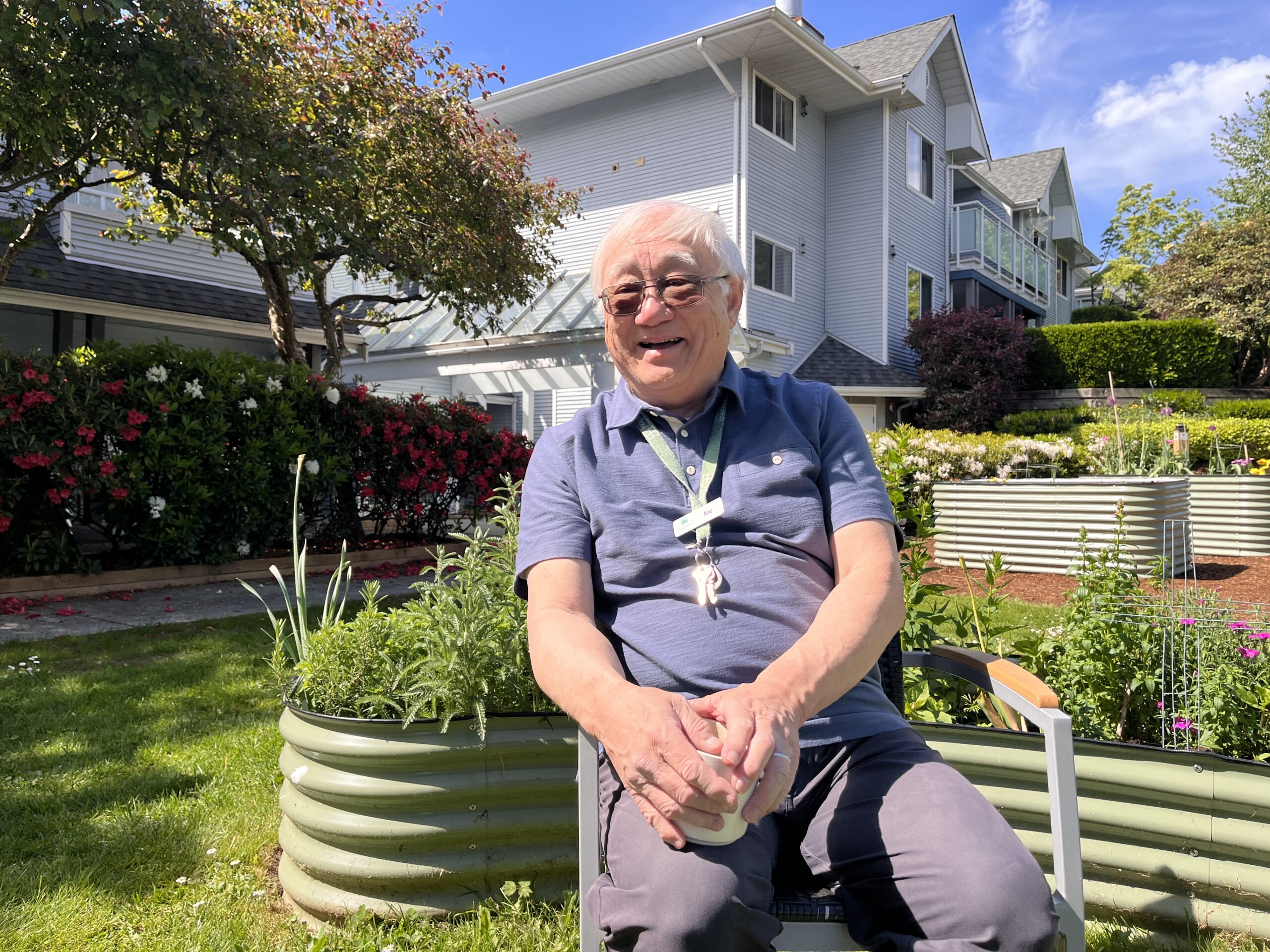 Joe smiling with coffee in garden